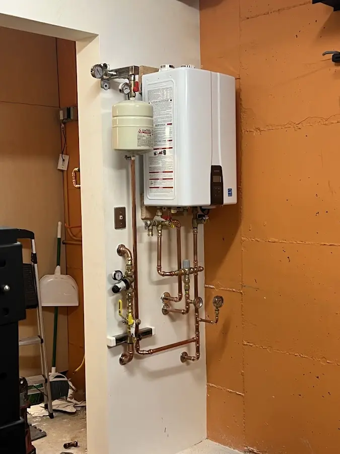 Plumbing technician inspecting water heater connections in Upper Chichester